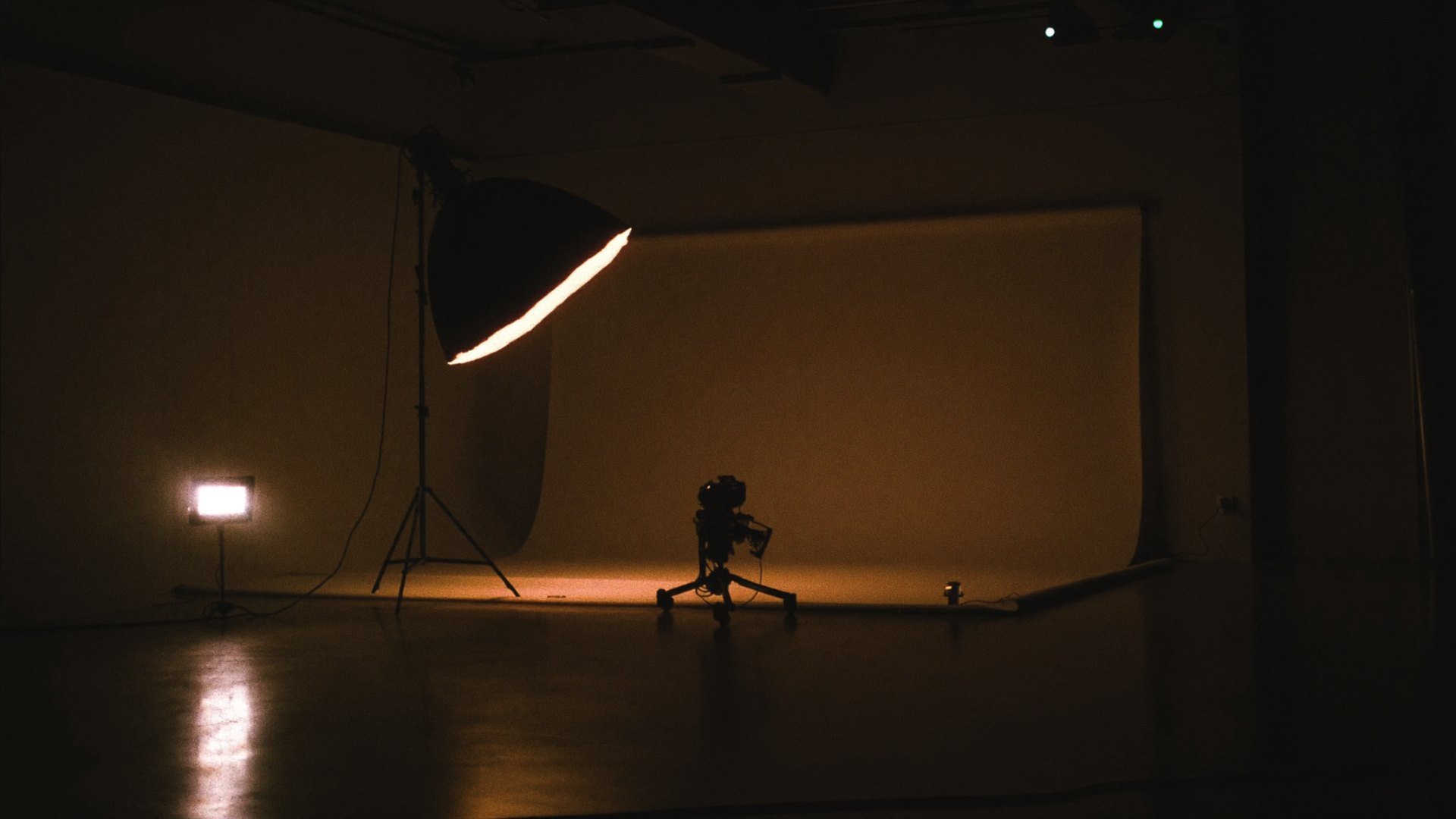 An empty creator studio at night lit by a single softbox